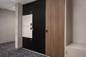 Ein Hotelzimmer mit Schrank, Teppichboden und einer schlichten Wand.