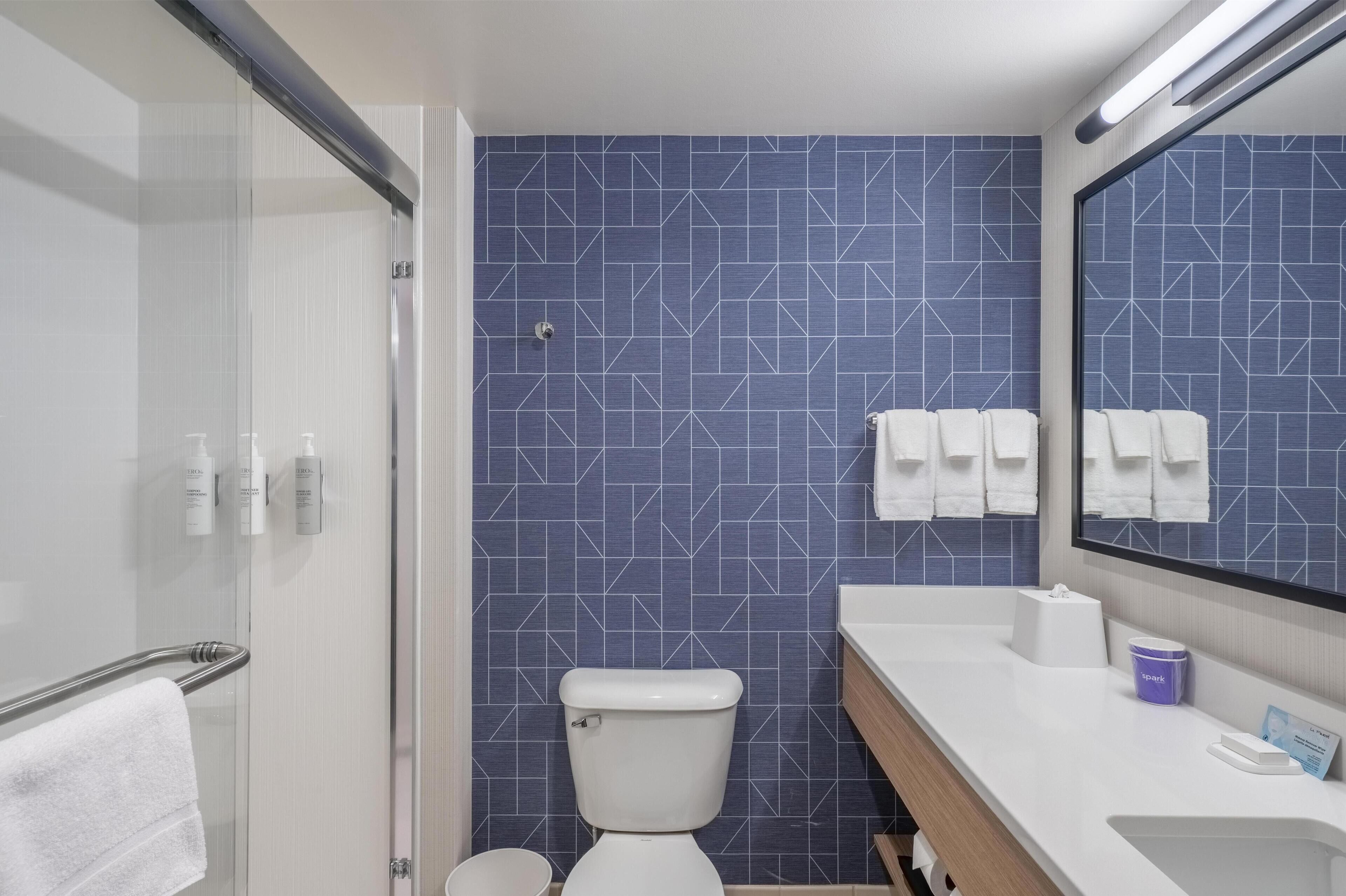 Un baño moderno con ducha, inodoro y lavamanos.
