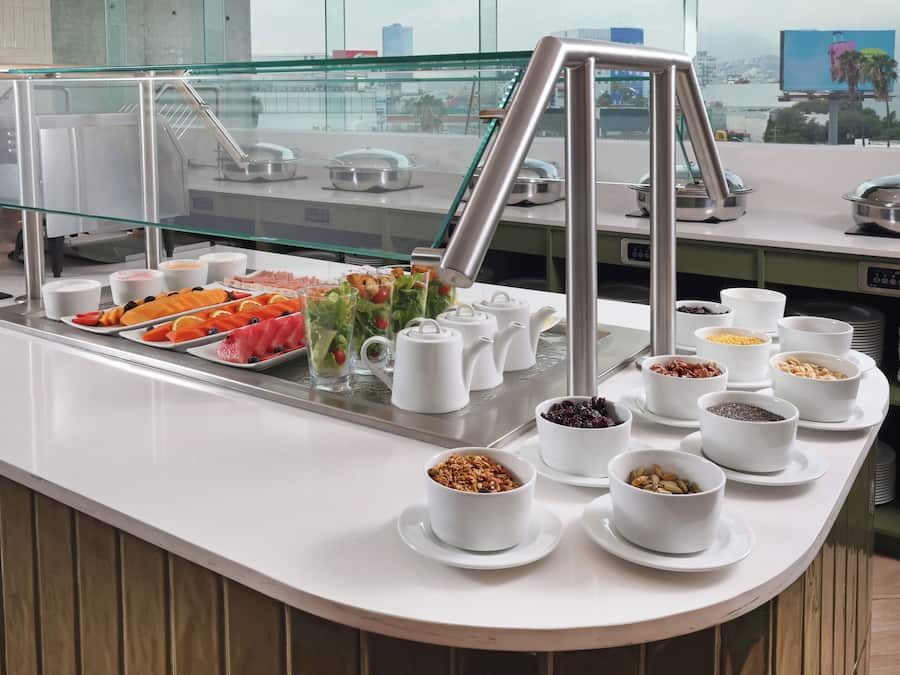 Zona de buffet con diversas opciones de comida y una vitrina de vidrio.