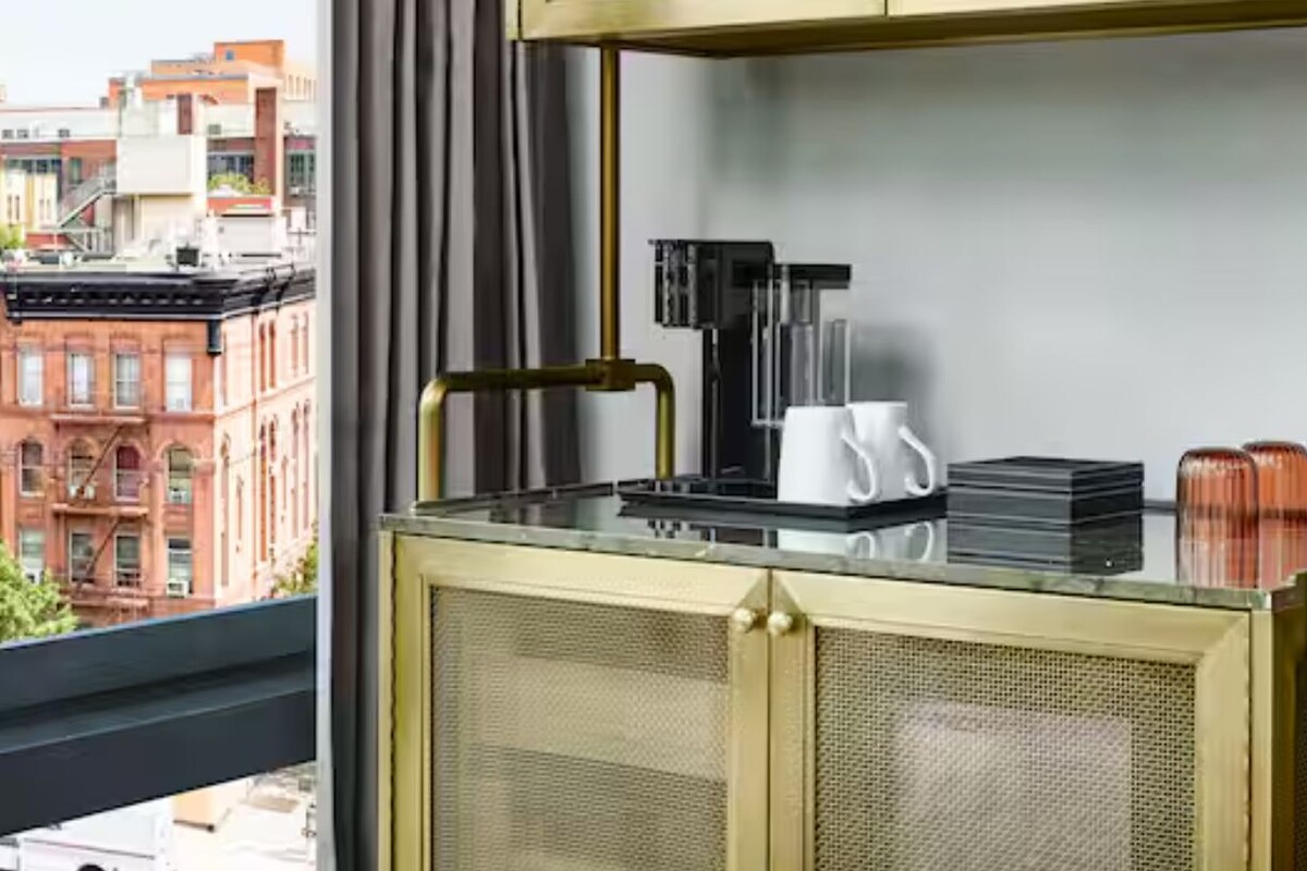 Eine moderne Küche mit Glasarbeitsplatte, goldenen Griffen und Blick auf die Stadt.