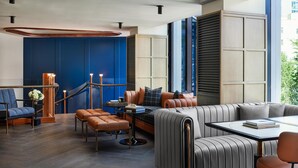 Un interior modern amb una paret d'accent blava, seients de pell i una escala.