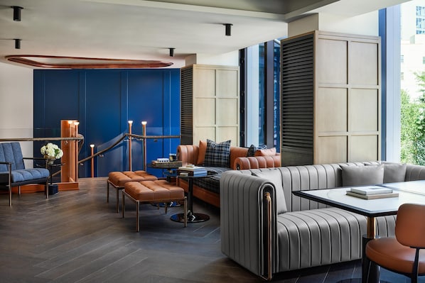 A modern interior with a blue accent wall, leather seating, and a staircase. - The George Manhattan, Tapestry Collection by Hilton+++ (New York)