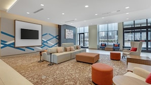 A spacious lobby with a large flat-screen TV, comfortable seating, and large windows. - Hilton Garden Inn Media Philadelphia (Media)