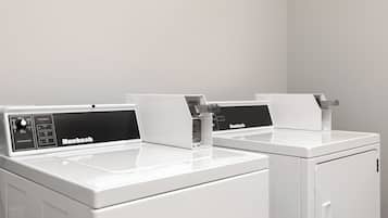 Dos lavadoras blancas Huebsch en un moderno y limpio cuarto de lavandería de diseño minimalista.