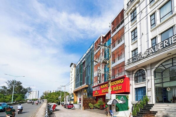 Un hotel con un letrero llamativo que anuncia 'HOTEL NAM DUONG HOANG HAU' y una 'GALERÍA' a la derecha.