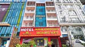 Hotel 'Hotel Nam Phuong Hoang Huu' con un llamativo letrero rojo, rodeado de otros edificios.