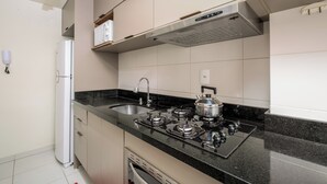 A modern kitchen with a gas stove, sink, and a built-in oven. - Apt in Cond. c/ Pool 5min From the Beach Mar202 (Florianópolis)
