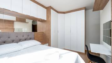 Un dormitorio con cama, escritorio y silla.