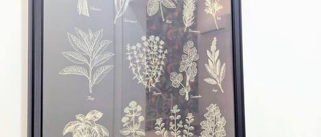 A framed botanical illustration titled "The Herb Garden" with various herb plants labeled.