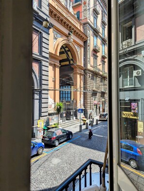 A street view with historic buildings, a cobblestone street, and parked cars. - La Locanda dell'Amore (Naples)