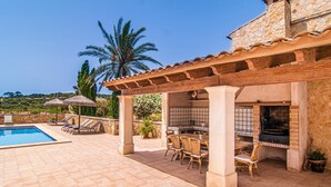 A pool area with a pergola, outdoor seating, and a stone building with a kitchen. - Gorgeous home in Felanitx with private swimming pool, can be inside or outside (Felanitx)
