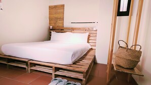 A single bed with a wooden headboard, a white mattress, and a pair of slippers on the floor. - KIVALA Hostel (Jincheng)