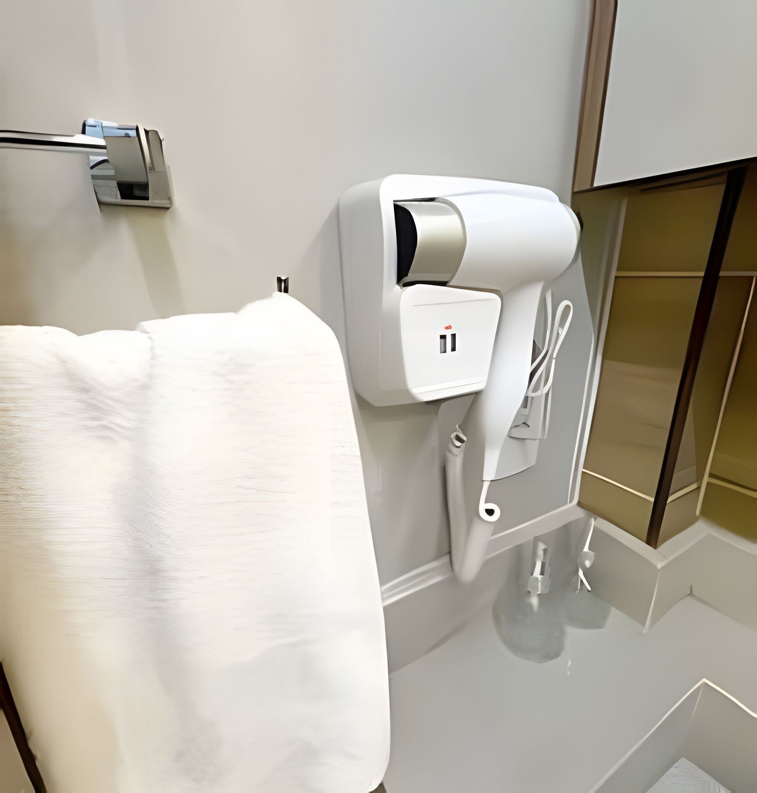 A modern bathroom with a towel rack, a built-in hair dryer, and a mirror.