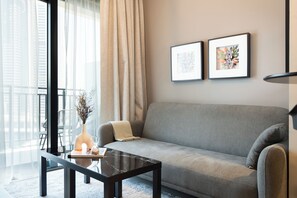 Deluxe Apartment | Living area | 125-cm flat-screen TV with digital channels