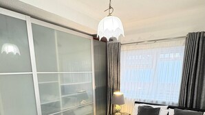 A hotel room with a large bed, a sliding door closet, a nightstand with a lamp, and a view of the city through the window. - Luxurious West London Retreat With Hot Tubs & Easy Access to Central London (Greenford)