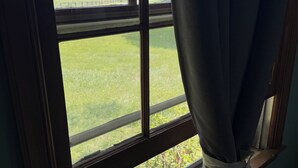 A window with a view of a green field and trees. - Charming Farmhouse near Inn at Little Washington (Washington)