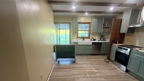 A spacious kitchen with light green cabinets, a wooden floor, and a built-in oven. - Charming Farmhouse near Inn at Little Washington (Washington)