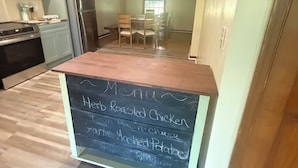 A kitchen with a chalkboard menu listing items like Herb Roasted Chicken and Mashed Potatoes. - Charming Farmhouse near Inn at Little Washington (Washington)