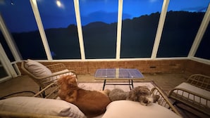 A room with wicker furniture, a solar panel, and a view of the mountains. - Charming Farmhouse near Inn at Little Washington (Washington)