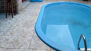 A swimming pool with a tiled deck, a barbecue area, and a potted plant. - Casa COP30 14 leitos, Condominio Segurança armada 24h (Tapanã Belém)