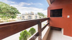 A balcony with a view of a street and buildings. - 2-bedr Ap W/bbq, 400m From the Beach Jurere Jba202 (Florianópolis)