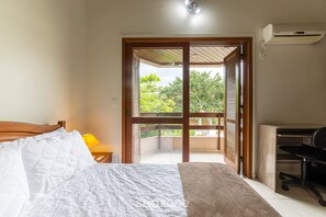 A bedroom with a bed, a desk, and a view of a balcony. - 2-bedr Ap W/bbq, 400m From the Beach Jurere Jba202 (Florianópolis)