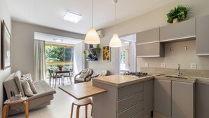 A modern kitchen with a central island, grey cabinets, and pendant lighting. - Sea View Apt 240m From the Beach in Jurere Ido207 (Florianópolis)
