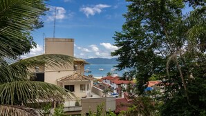 A coastal town with buildings, a clear sky, and boats on the water. - Sea View Apt 240m From the Beach in Jurere Ido207 (Florianópolis)