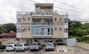 Un immeuble à plusieurs étages avec un espace de stationnement à l’avant.