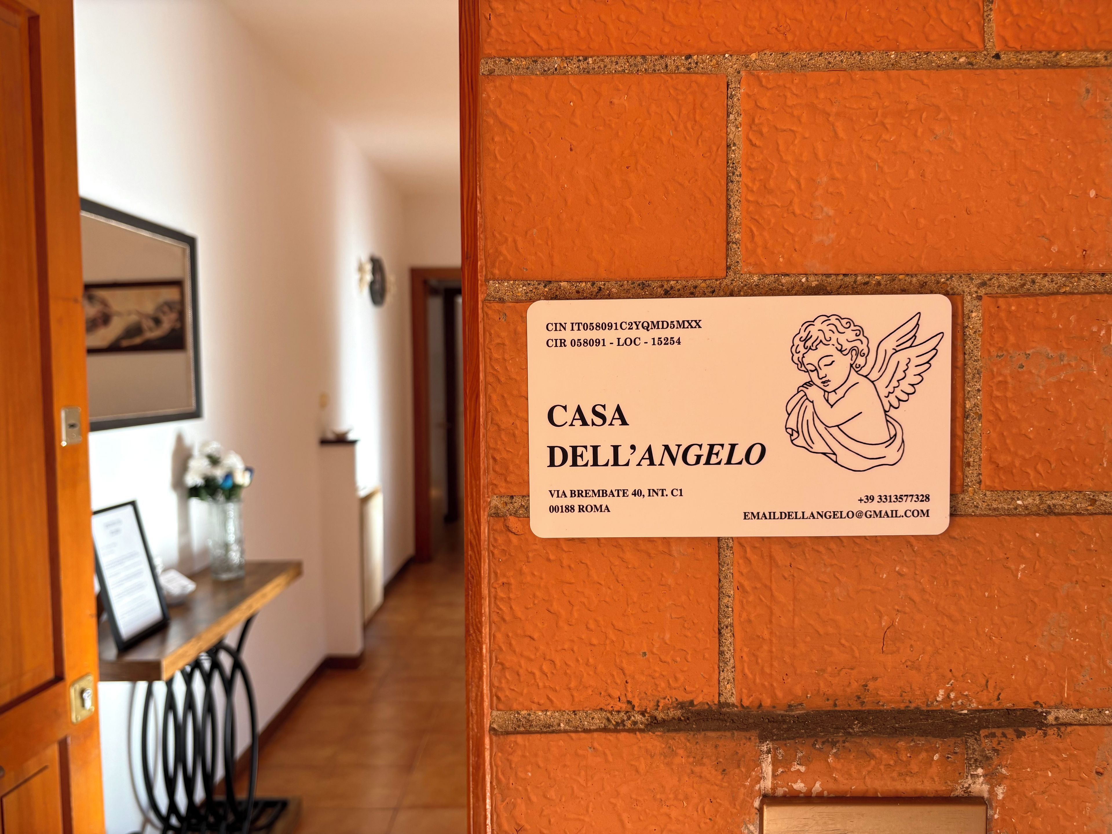 Ein Schild mit dem Namen 'CASA DELL'ANGELO' und Kontaktinformationen.