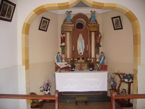 A chapel interior with a central statue, altar, and religious icons. - Room 'Nr 4' with Shared Terrace, Shared Garden and Wi-Fi (Simonswald)