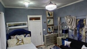 Ein Schlafzimmer mit einem Bett, einem Schminktisch, einem Spiegel und einer Chandelier.
