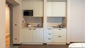 A modern kitchen with white cabinets, a microwave, and a sink. - Florence Dome Rooms (Florence)