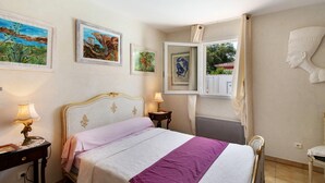 A bedroom with a bed, bedside tables, a window with curtains, and wall art. - Sea and Canopy Rooms: Mountain View, Shared Terrace and Garden (SARROLA CARCOPINO)
