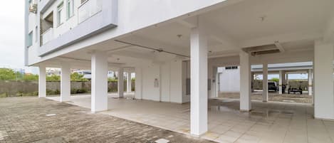 An empty building with a covered outdoor area, columns, and a tiled floor.