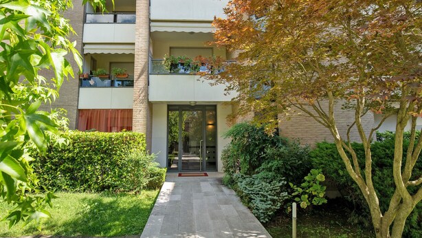 A multi-story building with balconies, a garden entrance, and a pathway leading to the door. - Casa Andrea with Balcony, Wi-Fi, and Air Conditioning (Venezia)
