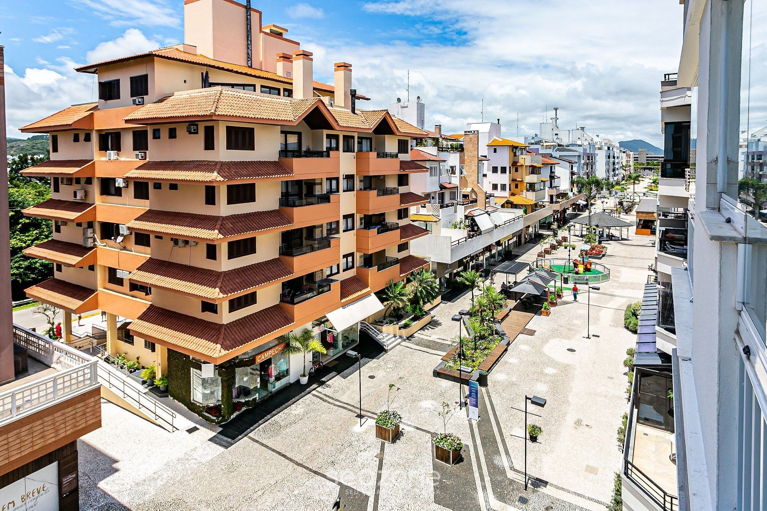 A multi-story residential building with balconies, a central courtyard, and a street view.