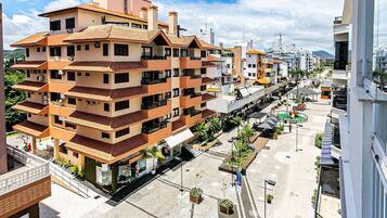 A multi-story residential building with balconies, a central courtyard, and a street view.
