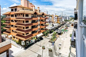 Un edificio residencial de varios pisos con balcones, un patio central y vista a la calle.