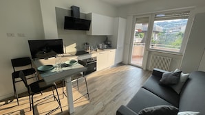 A modern kitchen with a dining area and a balcony.
