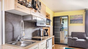 Una cocina moderna con microondas, cafetera y pileta de acero inoxidable.