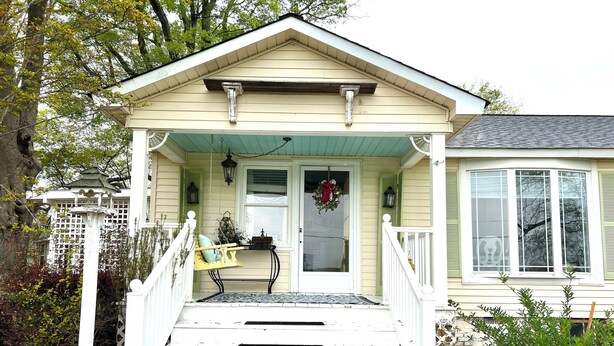A house with a porch, a bench, and a small garden area.