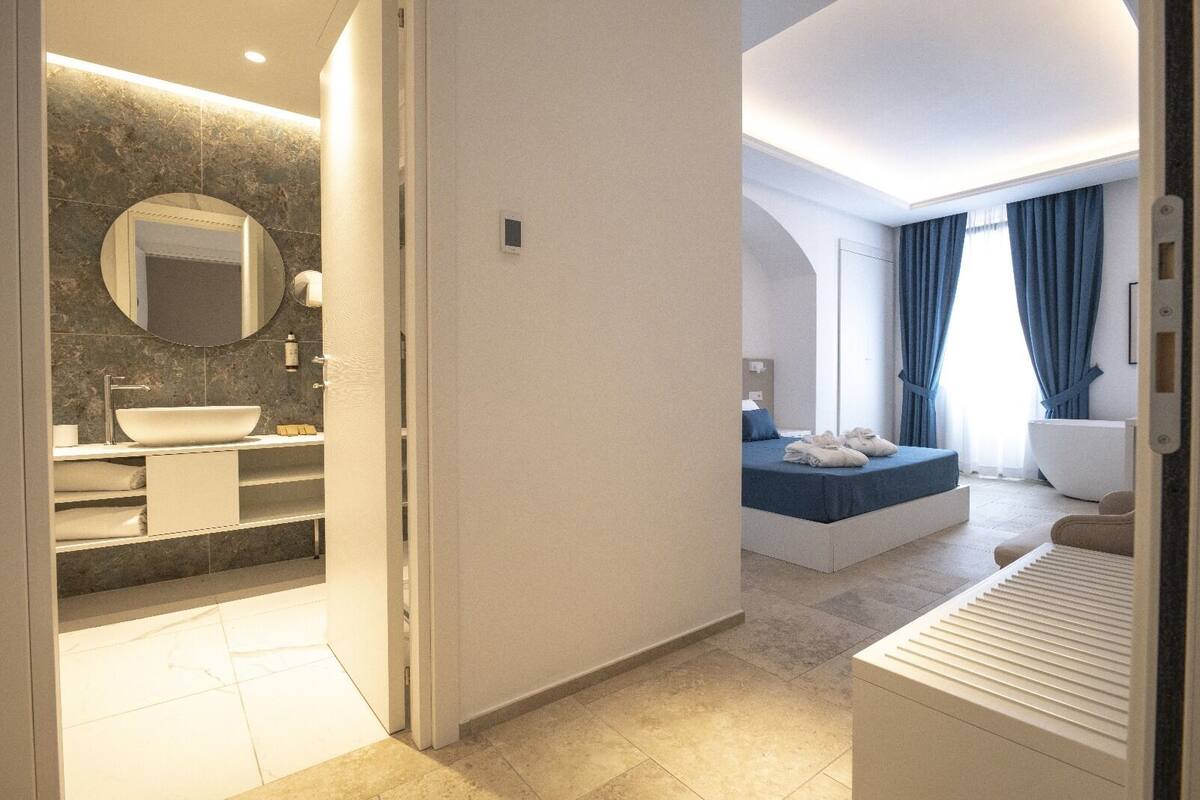 A modern bathroom with a large sink, mirror, and marble backsplash.