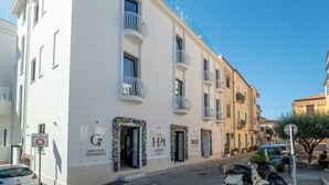 A white building with balconies, a sign for 'Hotel Palazzo Antonietta', and a 'Gran Caffè Antonietta' sign. - Hotel Palazzo Antonietta (Castellabate)