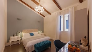 A bedroom with a bed, bedside tables, a chair, a window, and a chandelier. - Huge design apartment in the center of Venice, with private courtyard (Venezia)