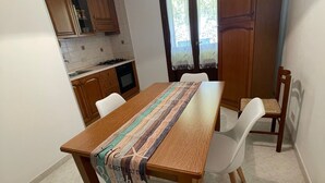 A dining area with a wooden table, white chairs, and a decorative table runner.