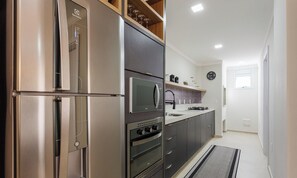 A modern kitchen with a built-in refrigerator, oven, and microwave. - Full Apartment at Ingleses Beach-sc Gge203 (Florianópolis)