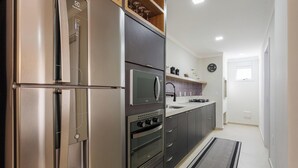A modern kitchen with a built-in refrigerator, microwave, and oven. - Full Apartment at Ingleses Beach-sc Gge203 (Florianópolis)