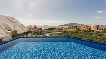 A rooftop pool with a clear view of the sea and surrounding buildings.