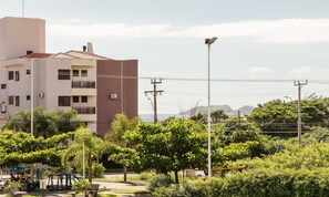 A residential building with multiple balconies, surrounded by lush greenery and a clear view of the sea. - Full Apartment at Ingleses Beach-sc Gge203 (Florianópolis)